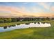 Aerial perspective of a golf course pond reflecting the sunset, surrounded by trees and houses at 3090 W 107 Pl # F, Westminster, CO 80031