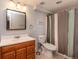 Functional bathroom with a wood vanity, neutral tiling, and striped shower curtain at 4921 Beach Ct, Denver, CO 80221