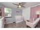 Bright Bedroom with a white crib, rocking chair, dresser, and decorative wall art, creating a welcoming space at 4921 Beach Ct, Denver, CO 80221