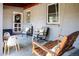 Inviting covered porch featuring comfortable seating, swing, and table for gathering at 4921 Beach Ct, Denver, CO 80221