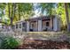 One-story home with xeriscaping, covered porch with swing, and lush trees at 4921 Beach Ct, Denver, CO 80221