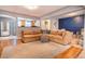 Open-concept living room with a sectional sofa, hardwood floors, and bright natural light at 4921 Beach Ct, Denver, CO 80221