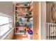 Walk-in pantry with wooden shelving, providing ample storage space for food and kitchen essentials at 4921 Beach Ct, Denver, CO 80221