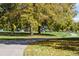 Picturesque park setting with mature trees, walking paths, and a vibrant playground in the background at 4921 Beach Ct, Denver, CO 80221
