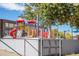 Bright and modern school playground area featuring climbing structures, slides, and a secure fenced perimeter at 4921 Beach Ct, Denver, CO 80221