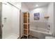 This bathroom showcases a tiled shower, tub, and storage cabinet with woven baskets at 1438 Little Raven St # 301, Denver, CO 80202