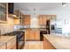 The well-lit kitchen shows a stainless steel refrigerator, wooden cabinets, granite countertops, and a gas cooktop at 1438 Little Raven St # 301, Denver, CO 80202