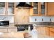 Close-up of the kitchen's granite countertops, gas cooktop, microwave, and wooden cabinets with glass fronts at 1438 Little Raven St # 301, Denver, CO 80202