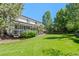 Expansive backyard featuring a well-manicured lawn, mature trees, and a charming covered patio at 2062 Hyacinth Rd, Highlands Ranch, CO 80129