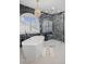 Bathroom featuring soaking tub, arched window, marble details and a glass shower at 2062 Hyacinth Rd, Highlands Ranch, CO 80129