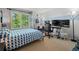 Bright bedroom with large window, blue accents, and a gaming setup at 2062 Hyacinth Rd, Highlands Ranch, CO 80129