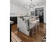 Stylish kitchen island featuring seating, modern lighting, and a seamless transition to the open concept living area at 2062 Hyacinth Rd, Highlands Ranch, CO 80129
