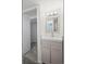 Bright bathroom with a vanity, stylish mirror, modern lighting, and a doorway to another room at 4573 S Acoma St, Englewood, CO 80110