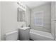 Updated bathroom featuring a tub, gray tiling, and modern vanity at 4573 S Acoma St, Englewood, CO 80110