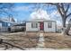 Charming single-story home featuring a red door, carport, and landscaped front yard at 4573 S Acoma St, Englewood, CO 80110