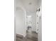 Hallway featuring stylish laminate flooring and an arched entryway, leading to a modern bathroom at 4573 S Acoma St, Englewood, CO 80110