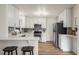 Modern kitchen features white cabinets, stainless appliances, and breakfast bar at 4573 S Acoma St, Englewood, CO 80110