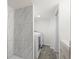 Modern laundry area with a new washer and dryer, stylish tile flooring, and a nearby shower at 4573 S Acoma St, Englewood, CO 80110