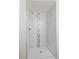 Modern shower featuring marble-like tile, a silver tile accent stripe, and modern fixtures at 4573 S Acoma St, Englewood, CO 80110
