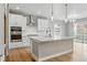 Modern kitchen with stainless steel appliances, white cabinets, and a large center island at 17196 W 92Nd Loop, Arvada, CO 80007