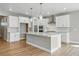 Modern kitchen featuring white cabinets, stainless steel appliances, and a large center island with pendant lighting at 17196 W 92Nd Loop, Arvada, CO 80007