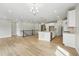 Bright open-concept living room and kitchen area, boasting hardwood floors and modern lighting at 17196 W 92Nd Loop, Arvada, CO 80007