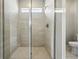Modern glass enclosed shower featuring tile surround, a built-in showerhead, and natural light at 17196 W 92Nd Loop, Arvada, CO 80007