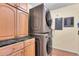 Laundry room with a stacked washer and dryer unit and wood cabinets with black marble countertop at 4066 S Atchison Way # 102, Aurora, CO 80014