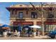 Exterior view of a red brick building with blue umbrellas and outdoor seating with tables at 1642 N Lafayette St # 2, Denver, CO 80218