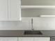 Close-up of kitchen sink, faucet, and cabinets with white subway tile backsplash at 1642 N Lafayette St # 2, Denver, CO 80218