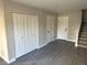 Neutral living room featuring gray wood-look floors, white doors, a closet, and staircase access at 1642 N Lafayette St # 2, Denver, CO 80218