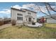Backyard features patio space, lush grass, and mature trees, creating a serene outdoor oasis at 5826 Sunburst Ave, Firestone, CO 80504