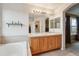 Bright, open bathroom with double vanity, soaking tub, and access to the main bedroom at 5826 Sunburst Ave, Firestone, CO 80504