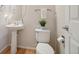 Neat half-bathroom with modern fixtures, pedestal sink, hardwood floors and plant for simple decoration at 5826 Sunburst Ave, Firestone, CO 80504