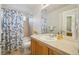 Well-lit bathroom featuring a bathtub and a shower combo with decorational flowers and large mirror at 5826 Sunburst Ave, Firestone, CO 80504