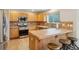 Bright kitchen with wooden cabinetry, tiled backsplash, and stainless steel oven at 5826 Sunburst Ave, Firestone, CO 80504