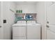 Functional laundry area with washer, dryer, storage shelf and cleaning supplies at 5826 Sunburst Ave, Firestone, CO 80504