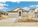 Charming single-story home featuring a stone facade, a gray garage, and a manicured front yard at 6187 E 155Th Pl, Thornton, CO 80602