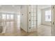 Bright hallway leading to a room with french doors and windows, and a staircase on the left at 6187 E 155Th Pl, Thornton, CO 80602