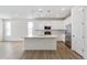 Spacious white kitchen with a large island, stainless steel appliances, and modern pendant lighting at 6187 E 155Th Pl, Thornton, CO 80602