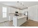 Updated kitchen features white cabinets, stainless appliances, and large center island with quartz countertop at 6187 E 155Th Pl, Thornton, CO 80602