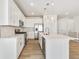 Bright kitchen with stainless steel appliances, white cabinets, and large island with pendant lighting at 6187 E 155Th Pl, Thornton, CO 80602
