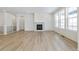 Spacious living room featuring light wood floors, a fireplace, and bright natural light at 6187 E 155Th Pl, Thornton, CO 80602