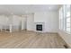 Spacious living room featuring light wood floors, a fireplace, and bright natural light at 6187 E 155Th Pl, Thornton, CO 80602