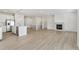 Open-concept living space featuring light wood floors, a fireplace, and modern finishes at 6187 E 155Th Pl, Thornton, CO 80602