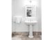 Small bathroom that features a pedestal sink, a mirror, and marble base trim at 140 Race St, Denver, CO 80206