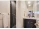 Bathroom with a modern black vanity, white countertop, decorative mirrors and tiled shower at 1217 E 26Th Ave, Denver, CO 80205