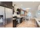 Modern kitchen with stainless steel appliances, dark cabinetry, and a bright dining area at 1217 E 26Th Ave, Denver, CO 80205