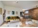 Spacious living room with hardwood floors, exposed brick wall, and open concept design at 1217 E 26Th Ave, Denver, CO 80205