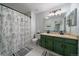 Updated bathroom features double sink vanity, floral shower curtain, and modern lighting at 4720 S Dudley St # 44, Littleton, CO 80123